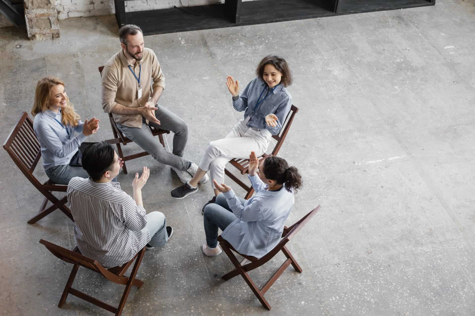 5 Menschen sitzen im Kreis und Unterhalten sich.